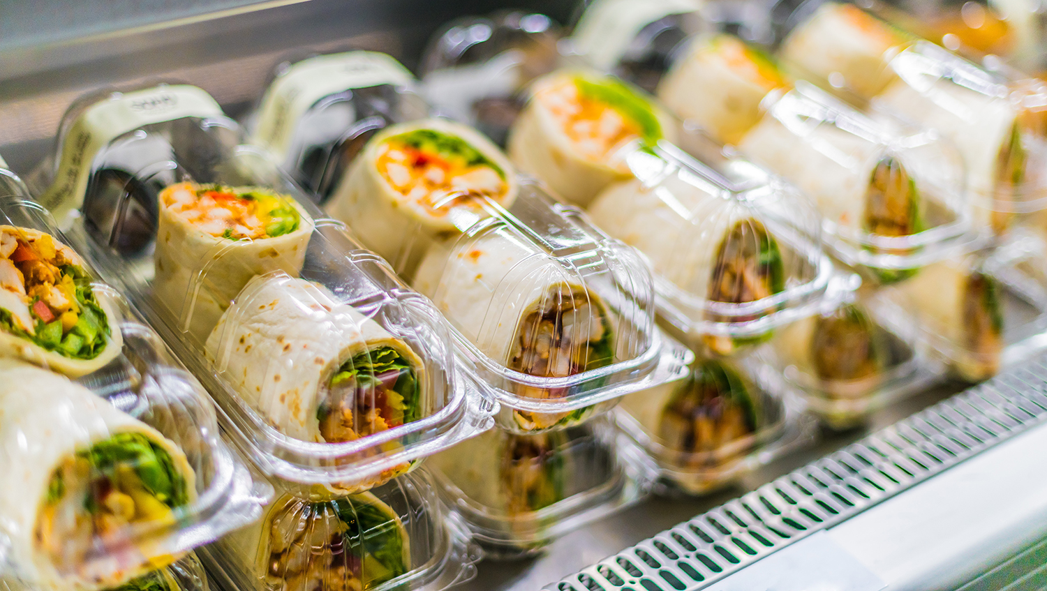 Display of deli wraps stored in clamshell packaging treated with silicone denesting agent TY25