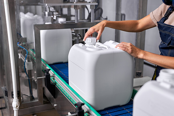 AdobeStock_466522728 A conveyor belt with a number of liquid storage containers created via rotational molding