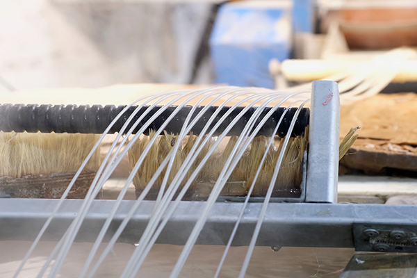 AdobeStock_494711504 A number of plastic rods being pulled out of an extrusion molding machine
