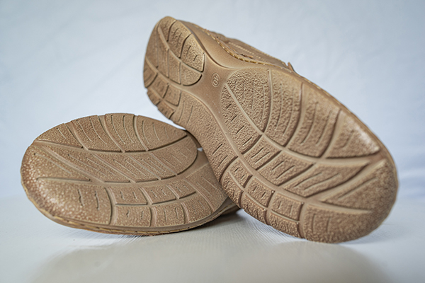 protect-surfaces a pair of tan shoes crossed on their sides, showcasing their soles