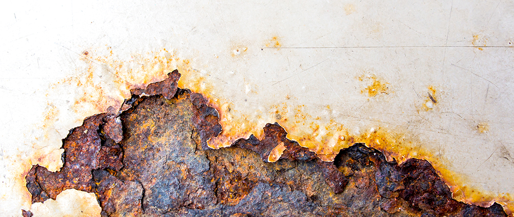A piece of white metal rusting and corroding away.
