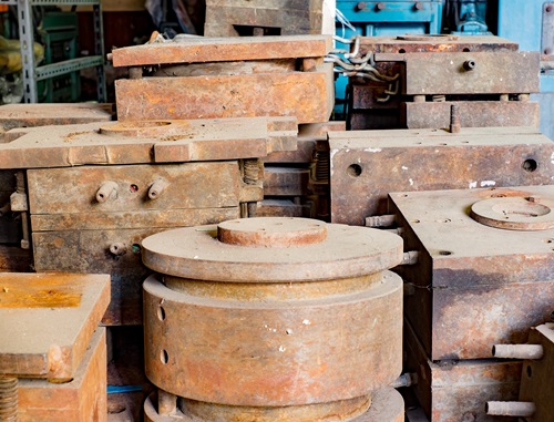 Old plastic injection molds in storage with rust.