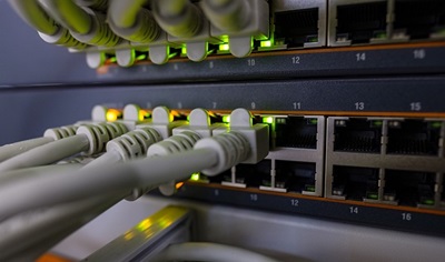 White network cables plugged into a lit-up router
