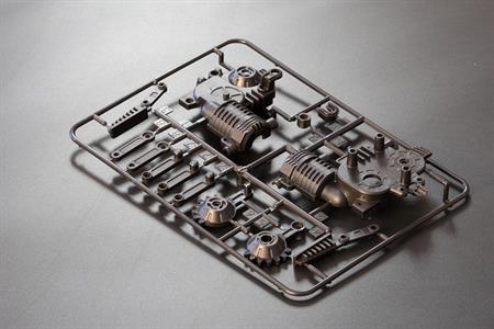 Dark grey injection molded parts on a table.