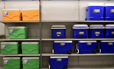 Blue, green, and yellow ice chest coolers on shelves.