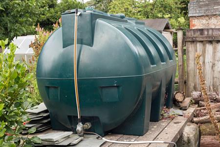 A green plastic fuel tank in a yard.