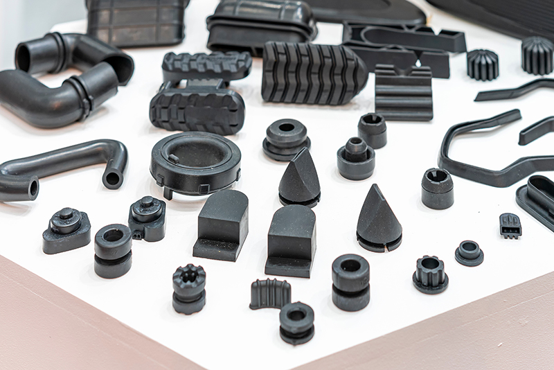 An array of black rubber pieces that have been created via compression molding
