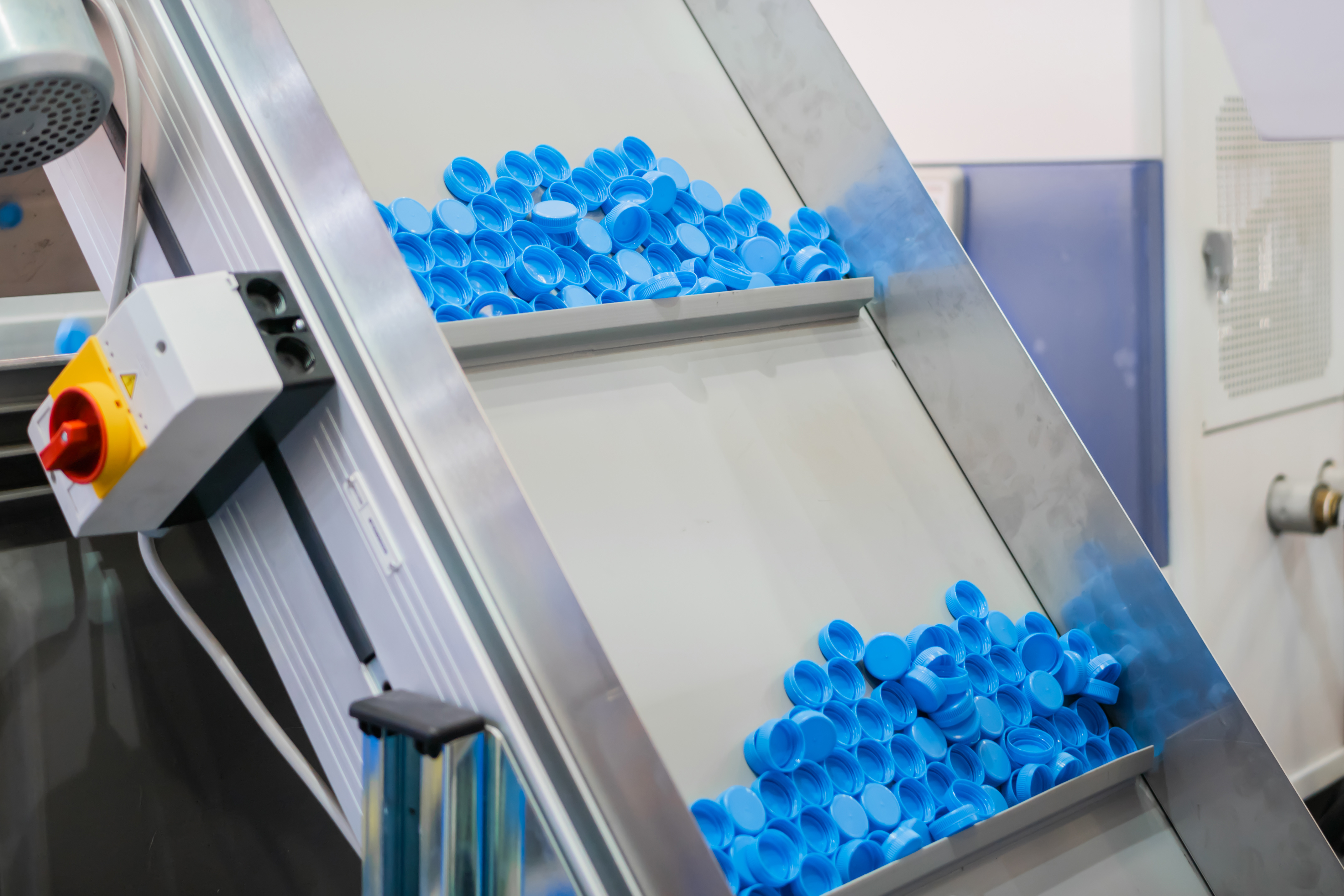 Blue bottle caps coming from a compression molding machine
