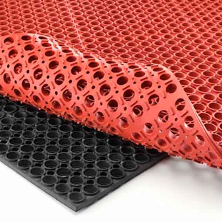 Red rubber sheets being released from a black molding surface 